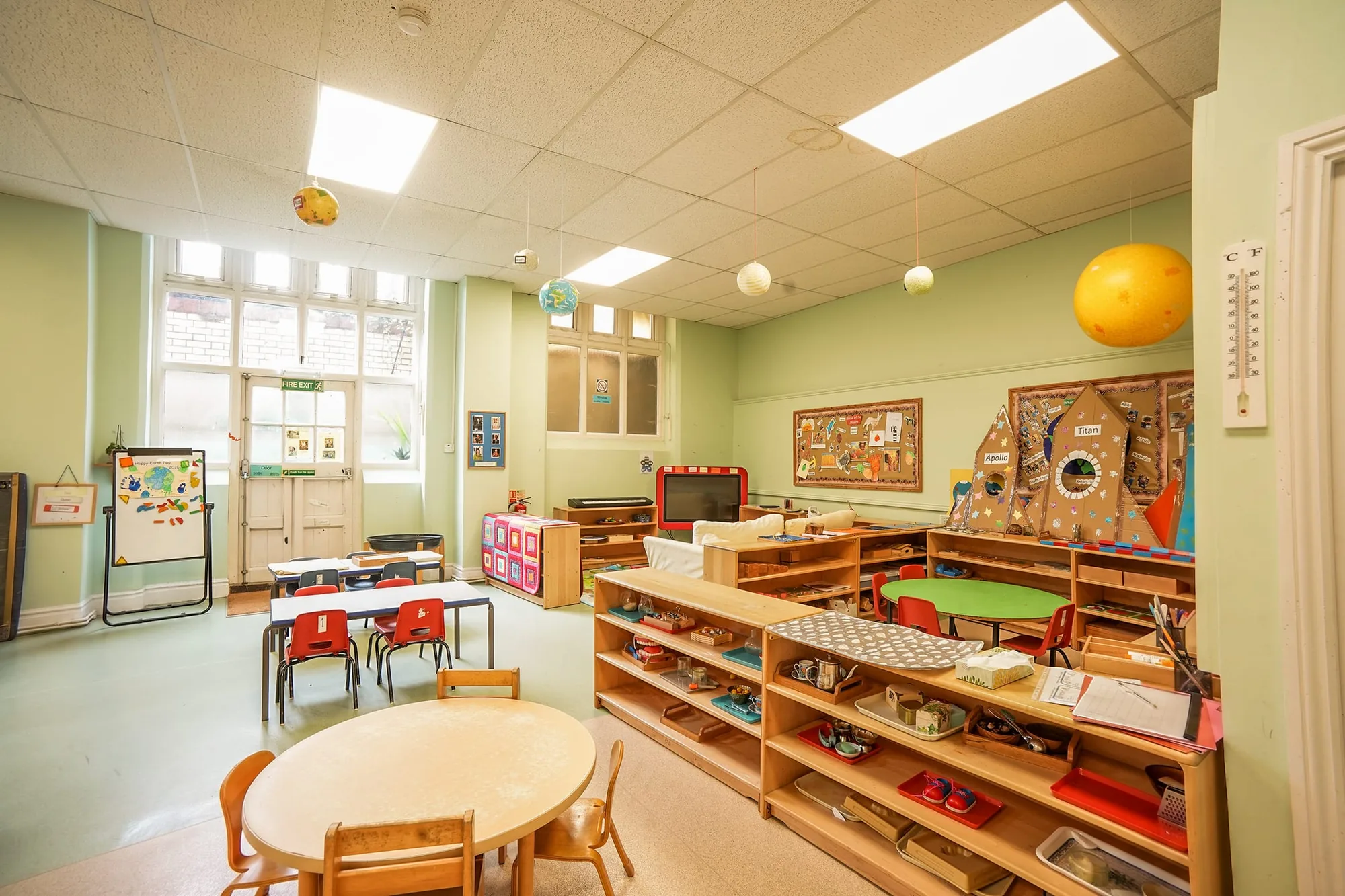 A bright Beckett House Montessori classroom with low wooden shelves and child-sized tables